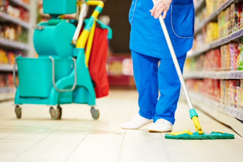 Persona limpiando el suelo de un supermercado